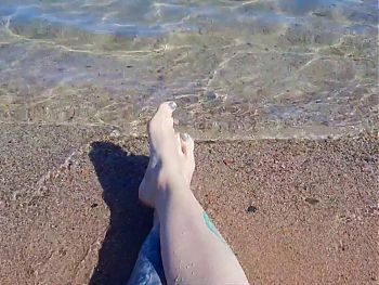 Dominatrix Nika enjoys the salty sea on her feet.      